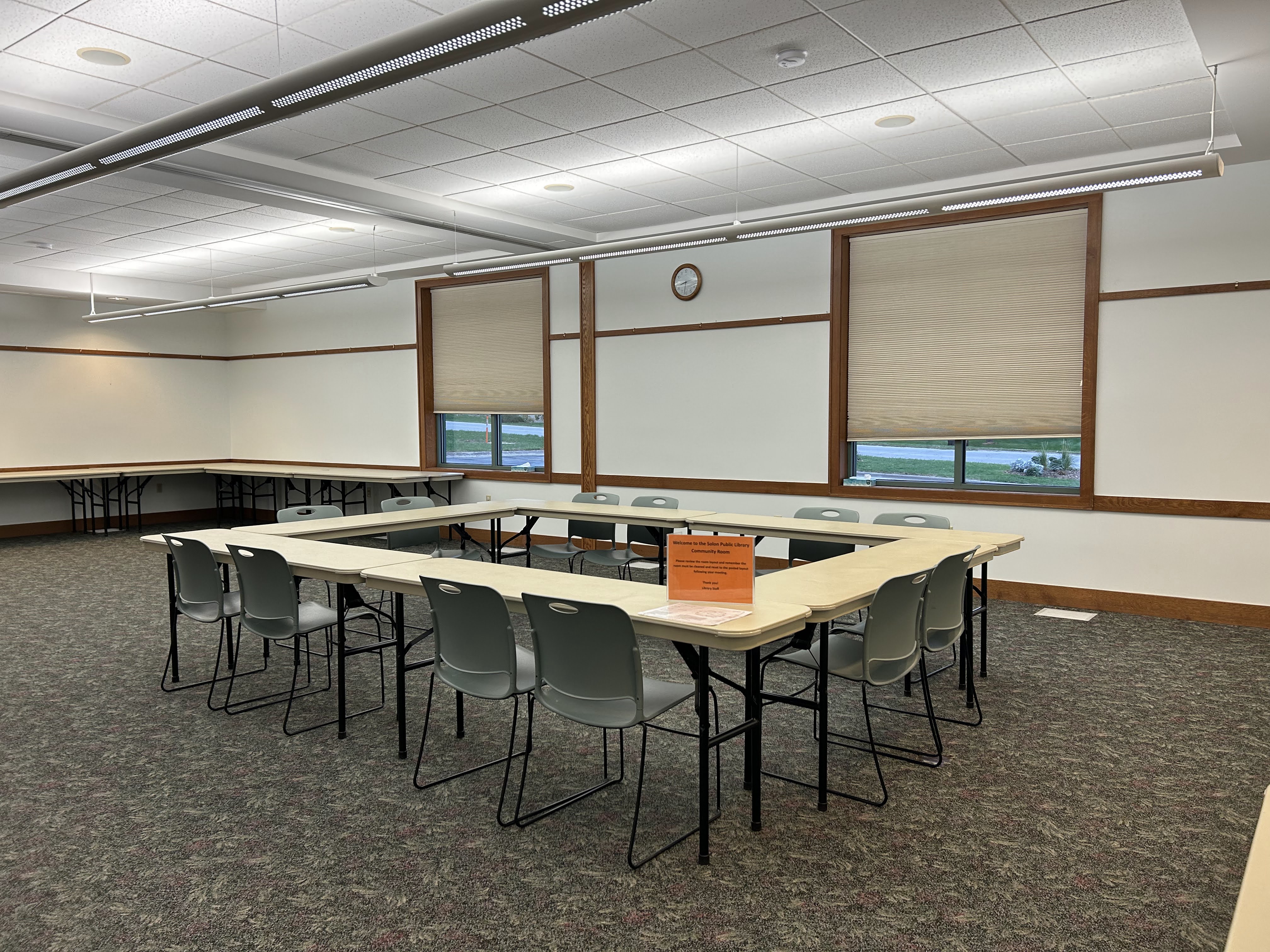 Photo of the community meeting room, standard layout with tables and chairs in a square.