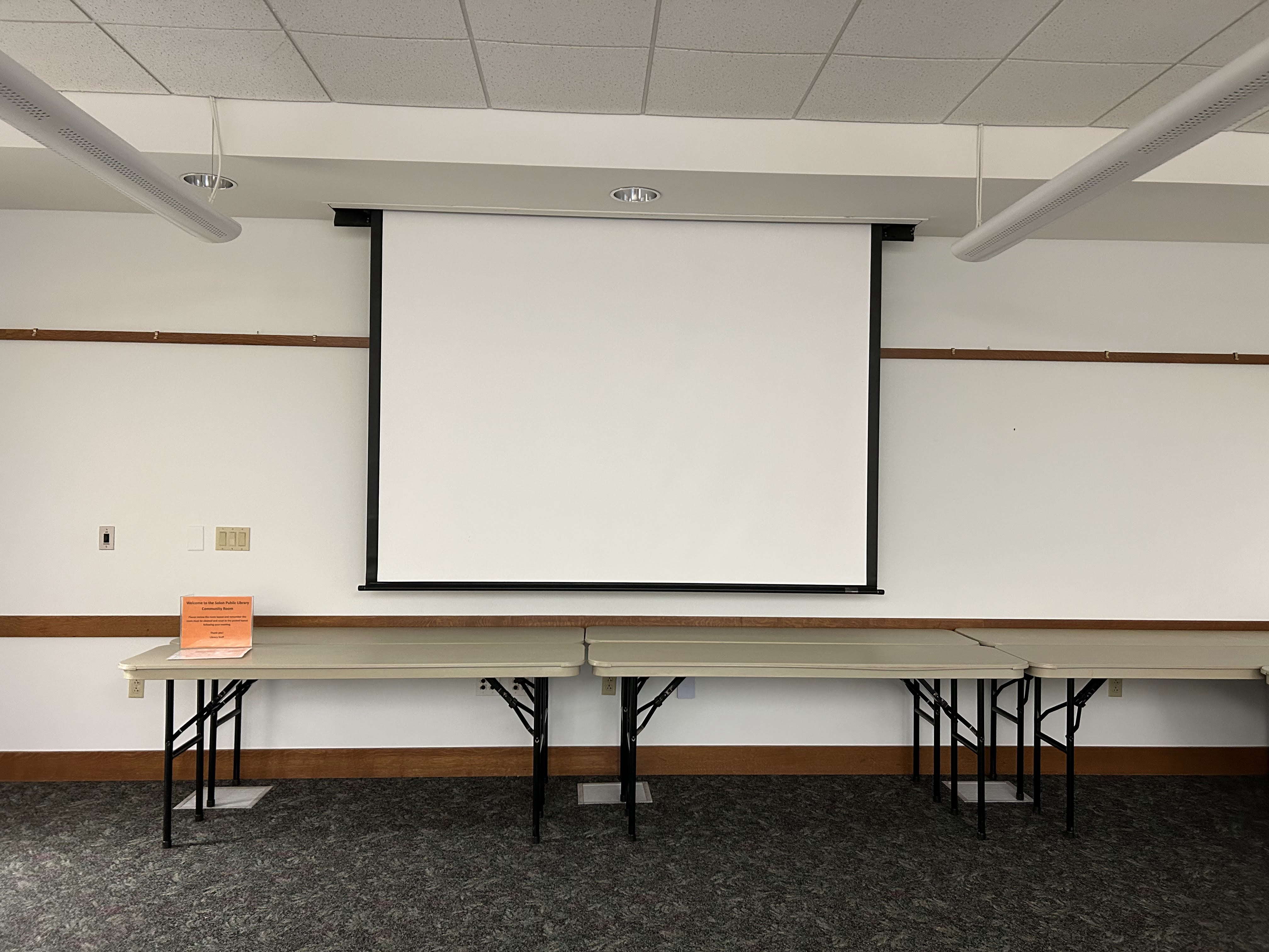 Photo of the community meeting room's projector screen, available upon request.