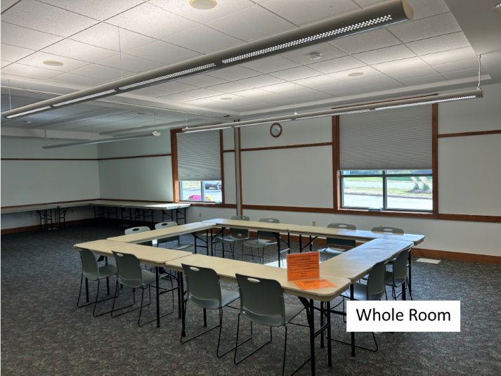 Photo of the community meeting room, standard layout with tables and chairs in a square.